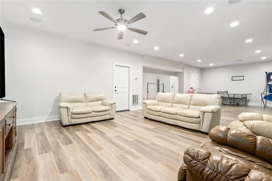 Ample space for recreation and relaxation, this bright basement features durable flooring and a contemporary aesthetic.