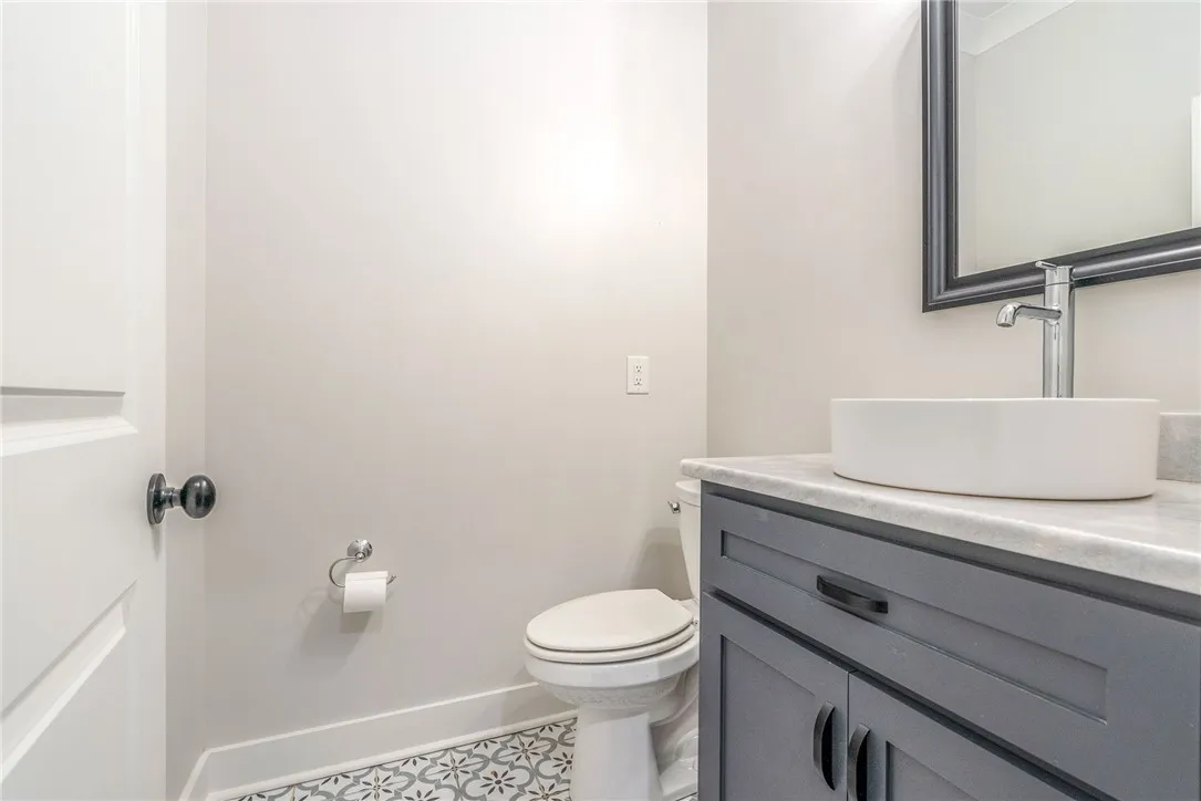 An inviting powder room features a modern vessel sink atop a marble-topped vanity.