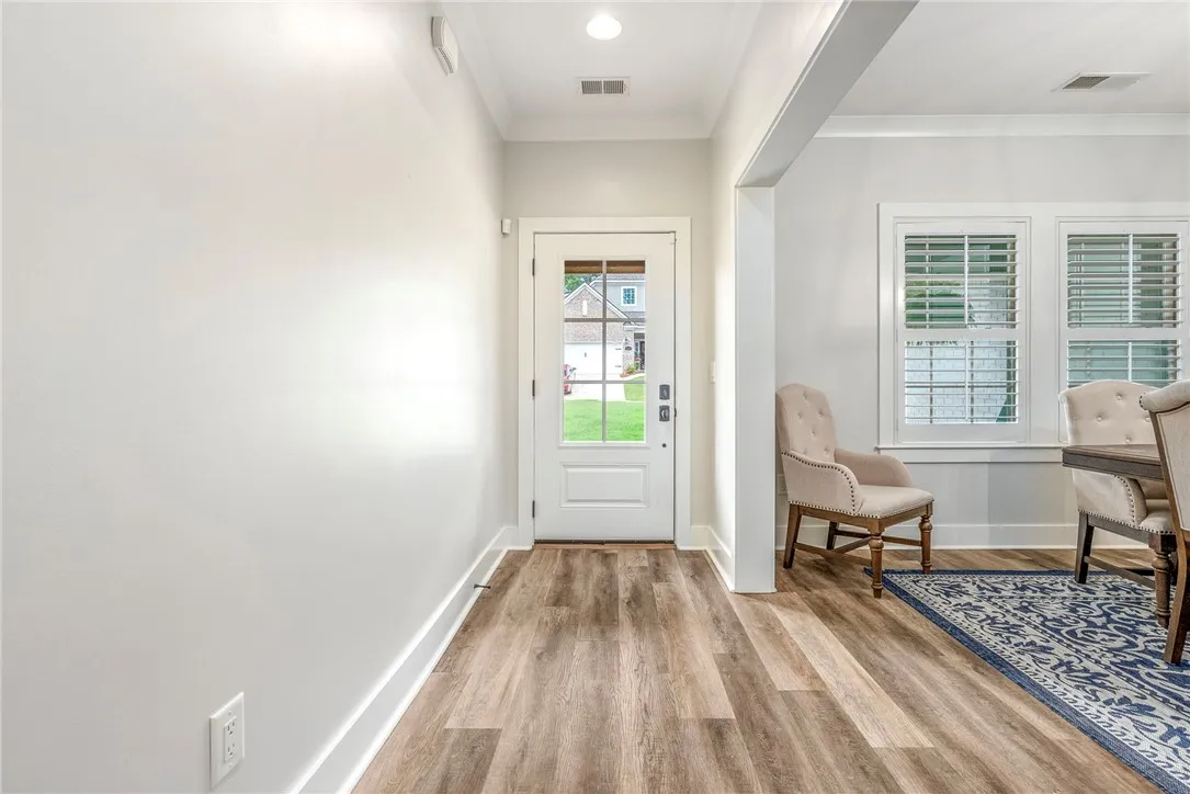 A welcoming entry offers views of the front yard, transitioning to an adjacent dining area with well-lit windows.