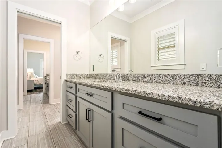 Granite counters and tiled flooring outfit this functional and practical bathroom vanity area.