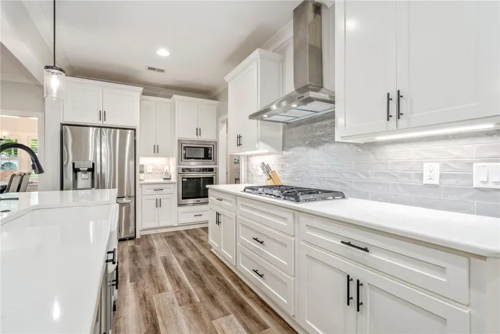 White cabinetry and stainless steel appliances complete this bright, modern culinary space.