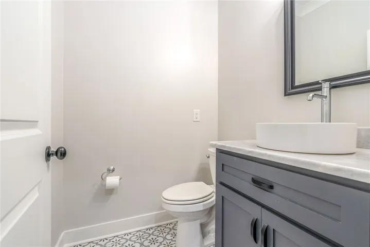 An inviting powder room features a modern vessel sink atop a marble-topped vanity.