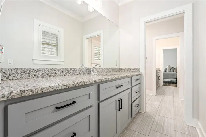 Granite counters and light gray cabinetry define this well-appointed bathroom space.
