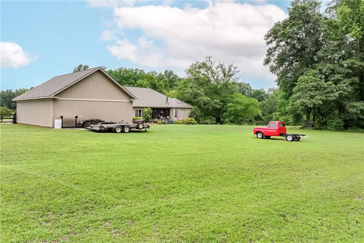 Vast green acreage surrounds this inviting home and large outbuilding, offering ample space and privacy.