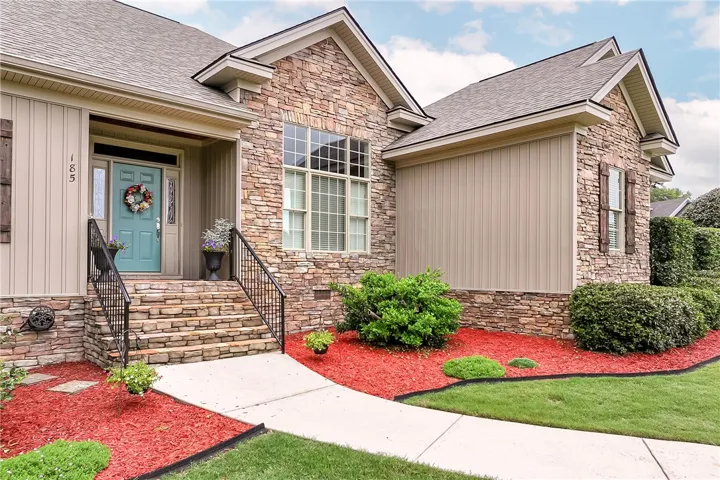 A stone facade welcomes you home with a meticulously landscaped front yard and inviting entry.