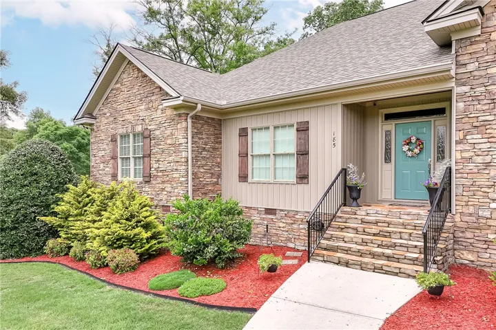 A welcoming stone and siding facade offers excellent curb appeal with manicured landscaping.