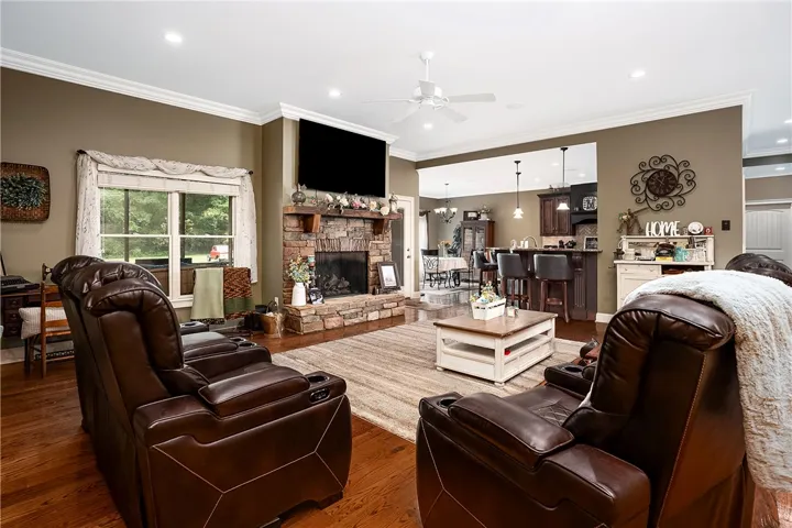 A stone fireplace anchors this inviting living space, flowing into a casual dining area and kitchen.