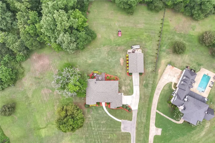 An aerial perspective showcases a sprawling estate with mature trees and a tranquil outdoor pool.
