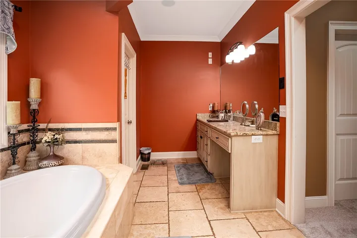 Luxurious soaking tub and dual vanity set in a spacious, richly colored bathroom.