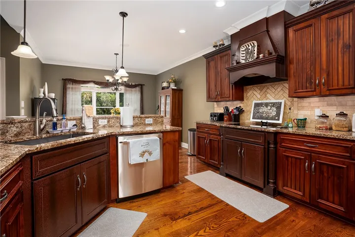Rich wood cabinetry and granite counters define this inviting kitchen space, perfect for culinary endeavors.