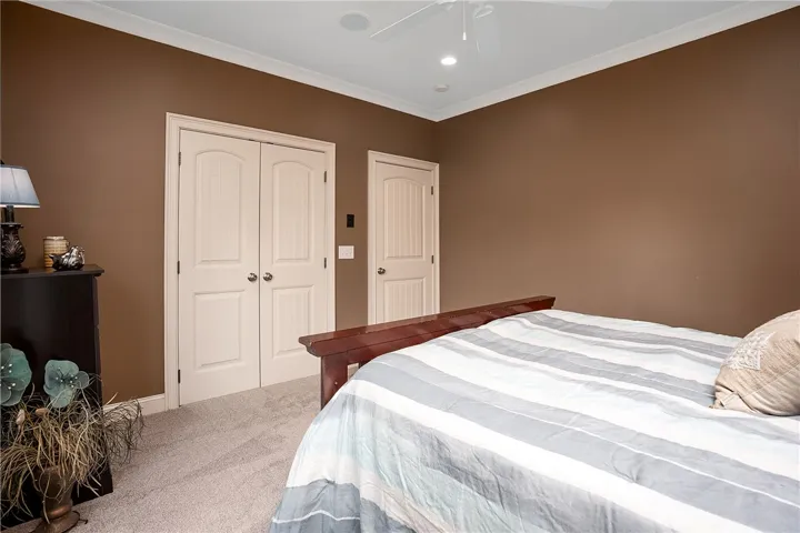 Plush carpeted bedroom features crown molding and convenient closet access.
