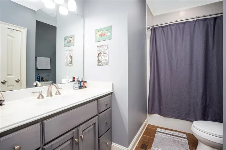 A neutral-toned vanity with brushed nickel hardware grounds this well-appointed bathroom.