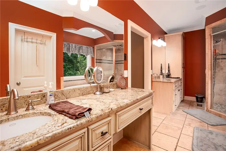 Indulge in a primary bathroom featuring a spacious vanity and a walk-in shower for ultimate comfort.