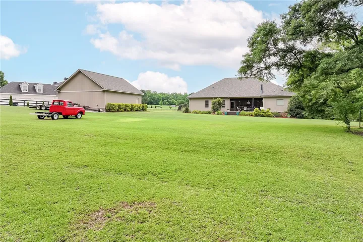 A well-maintained lawn stretches out before a charming residence with a covered patio.