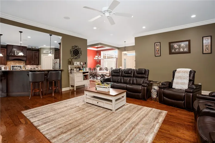 An inviting open-concept living space boasts gleaming hardwood floors and recessed lighting throughout.