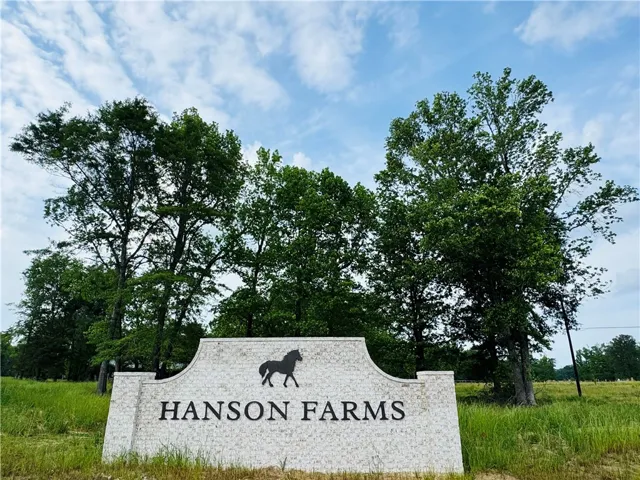 A welcoming stone sign, adorned with a horse silhouette, marks the entrance to Hanson Farms.