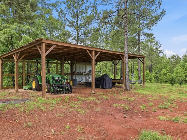 A robust, open-air shed provides ample storage and protection for equipment within this verdant property.