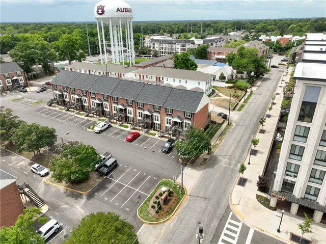 An aerial perspective reveals a vibrant neighborhood with townhomes, streets, and an iconic water tower.