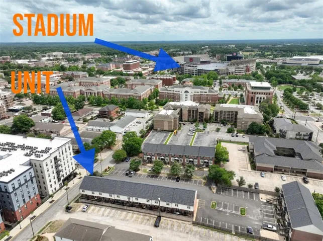 An aerial panorama reveals a campus setting with a grand stadium and ample parking facilities.