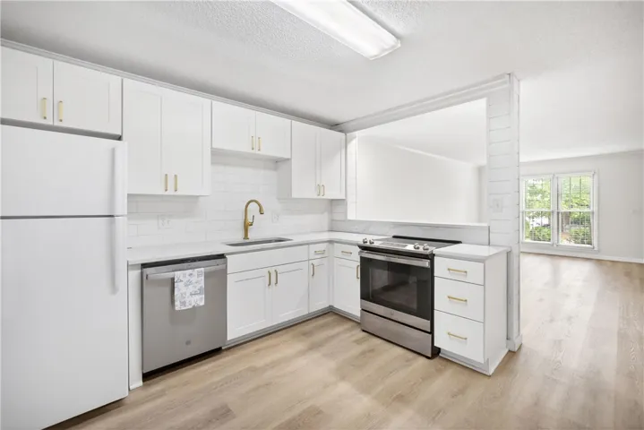 A well-appointed kitchen features modern appliances and elegant gold fixtures for a contemporary culinary experience.