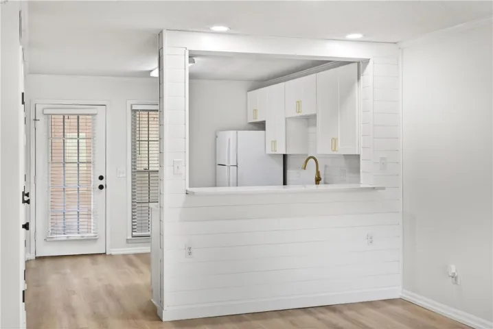 A well-lit kitchen featuring clean white cabinetry and a convenient breakfast bar.