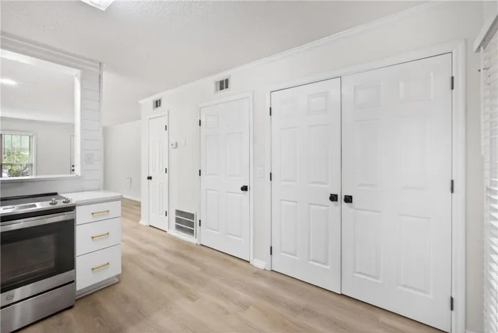 Modern kitchen with sleek stainless steel appliances and abundant white cabinetry for seamless storage.