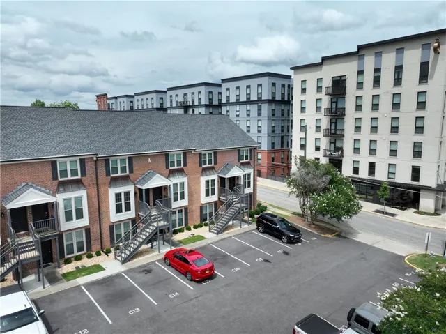 A well-maintained brick townhouse community with dedicated parking, situated in a vibrant urban setting.