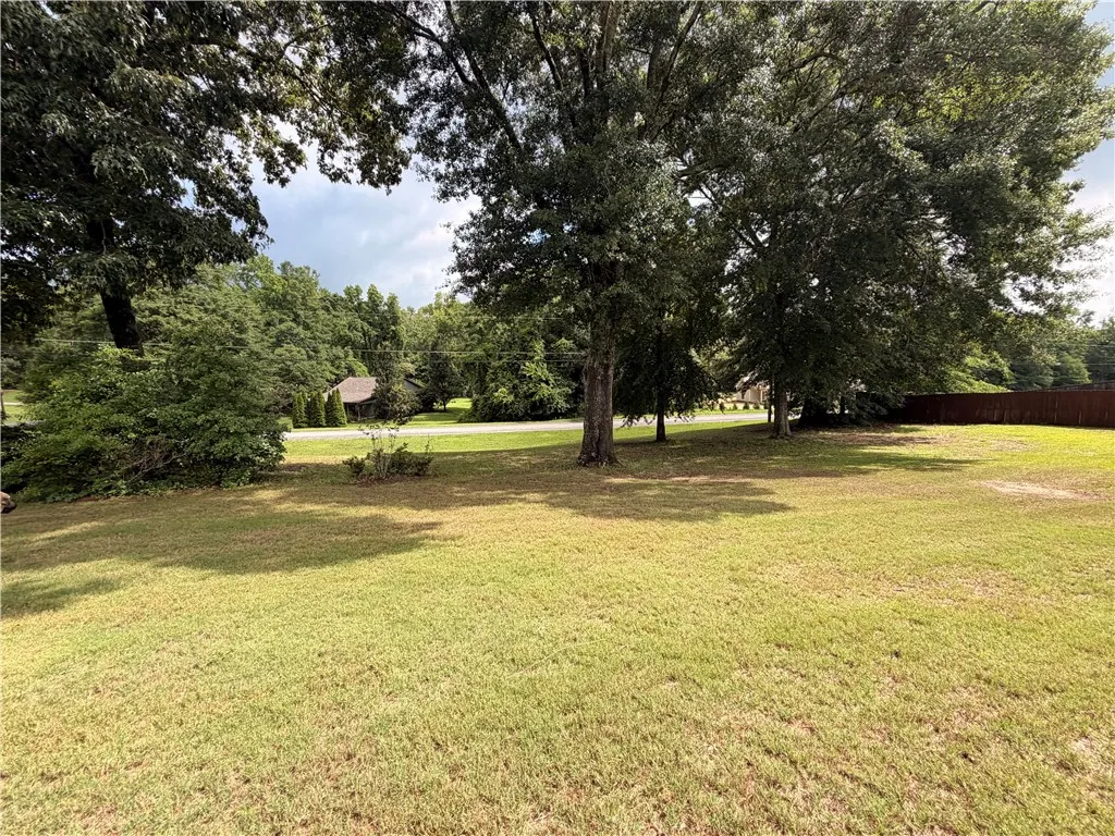 Green expanse with mature trees, offering a tranquil setting.