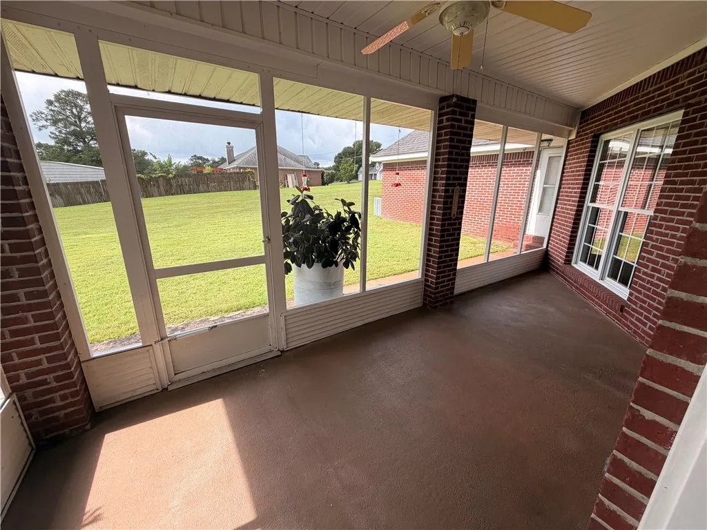 Relax and unwind in this inviting screened-in porch with views of the sprawling lawn.