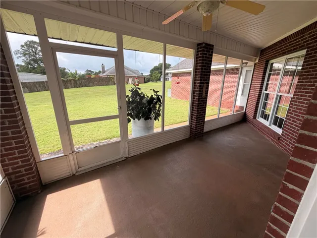 Relax and unwind in this inviting screened-in porch with views of the sprawling lawn.