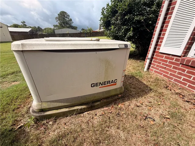 An essential generator provides reliable power, nestled against a classic brick home.