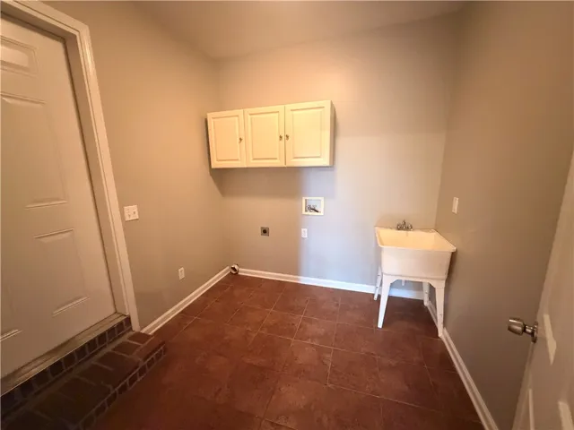 Functional utility space with durable tile flooring and a convenient utility sink.