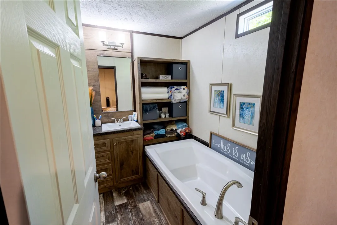 Relax and rejuvenate in this inviting primary bathroom, featuring a deep soaking tub and a functional vanity.