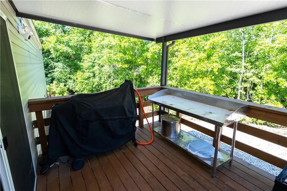 A spacious covered deck extends into nature's embrace, perfect for outdoor cooking and entertaining.