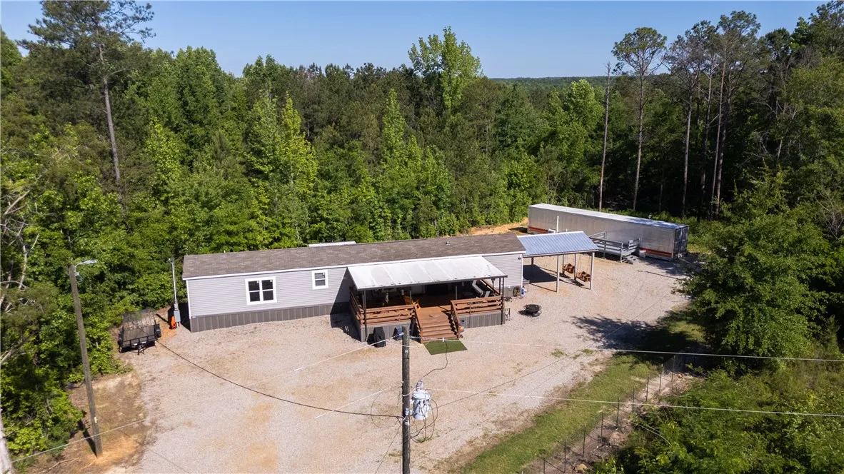 Perched amidst a verdant landscape, this secluded property features a spacious porch ideal for outdoor enjoyment.