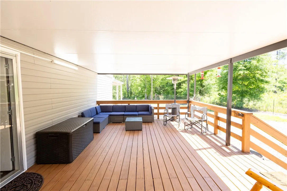 Relax in comfort on this spacious covered deck, offering tranquil views of the surrounding natural landscape.