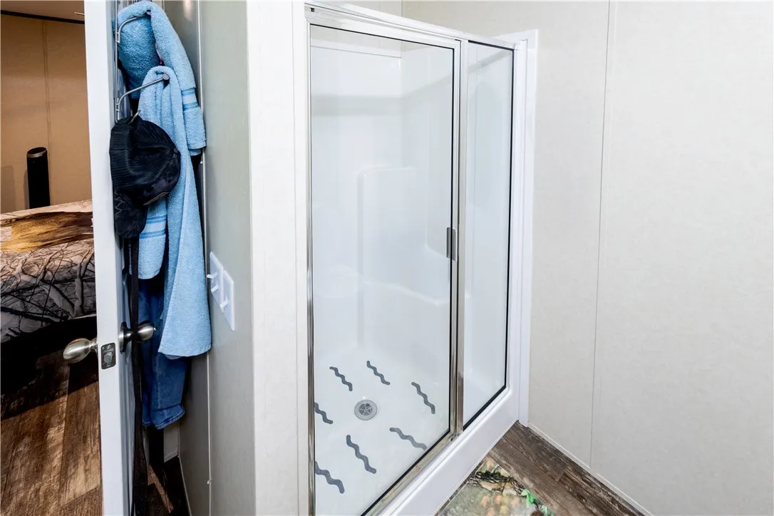A glass-enclosed shower stall with a clear door offers a functional and efficient bathing space.