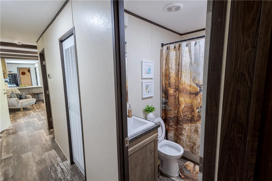 Functional full bathroom with shower-tub combo and wood-look flooring.