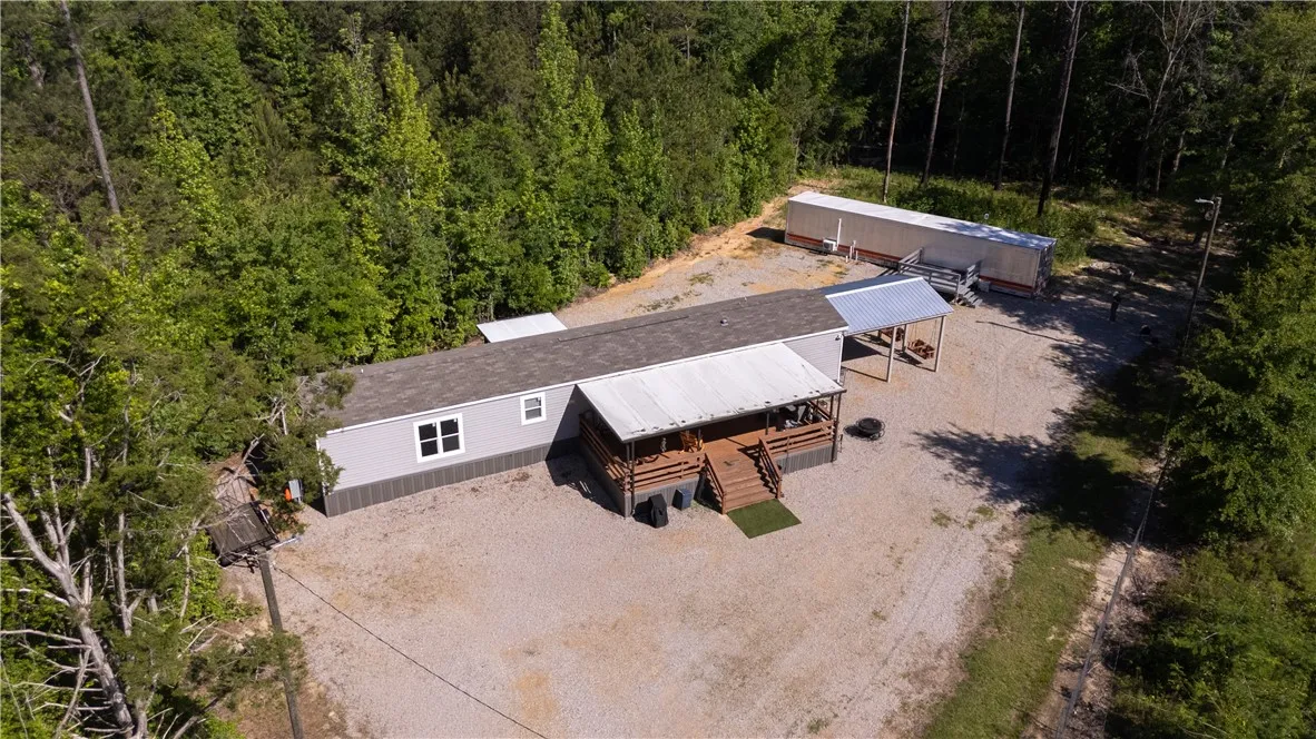 A private, gravel-paved lot with ample parking and a spacious covered porch awaits.