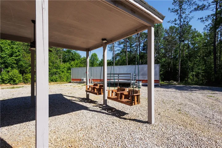 A tranquil covered patio offers outdoor seating with a view of the natural surroundings.