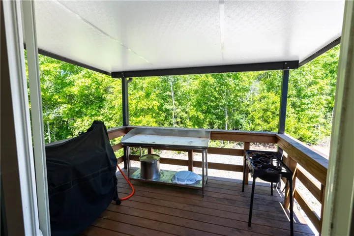 An inviting covered deck with serene forest views creates an ideal outdoor cooking and entertaining space.