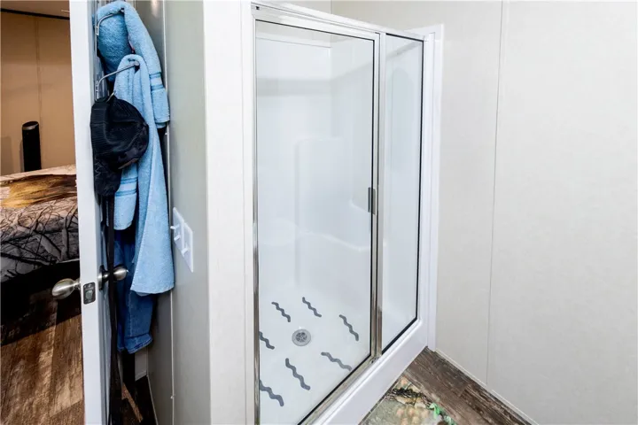 A glass-enclosed shower stall with a clear door offers a functional and efficient bathing space.