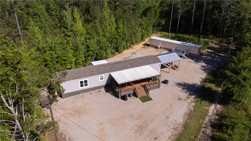 A private, gravel-paved lot with ample parking and a spacious covered porch awaits.
