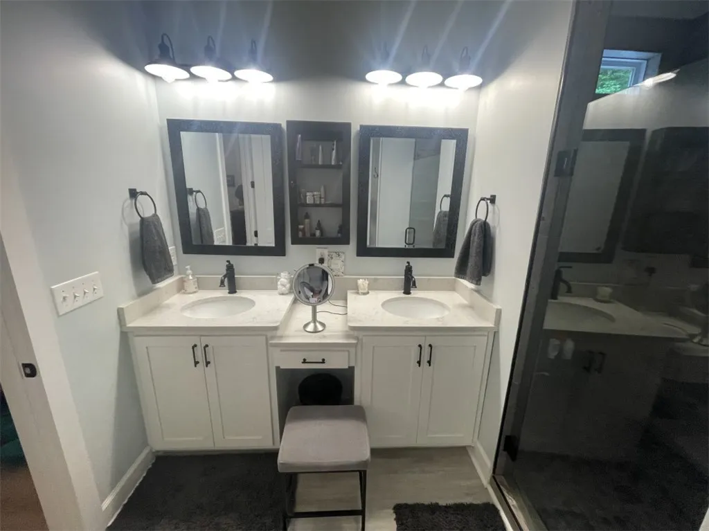 Twin vanities with elegant black fixtures and matching framed mirrors create a harmonious and functional bathing space.