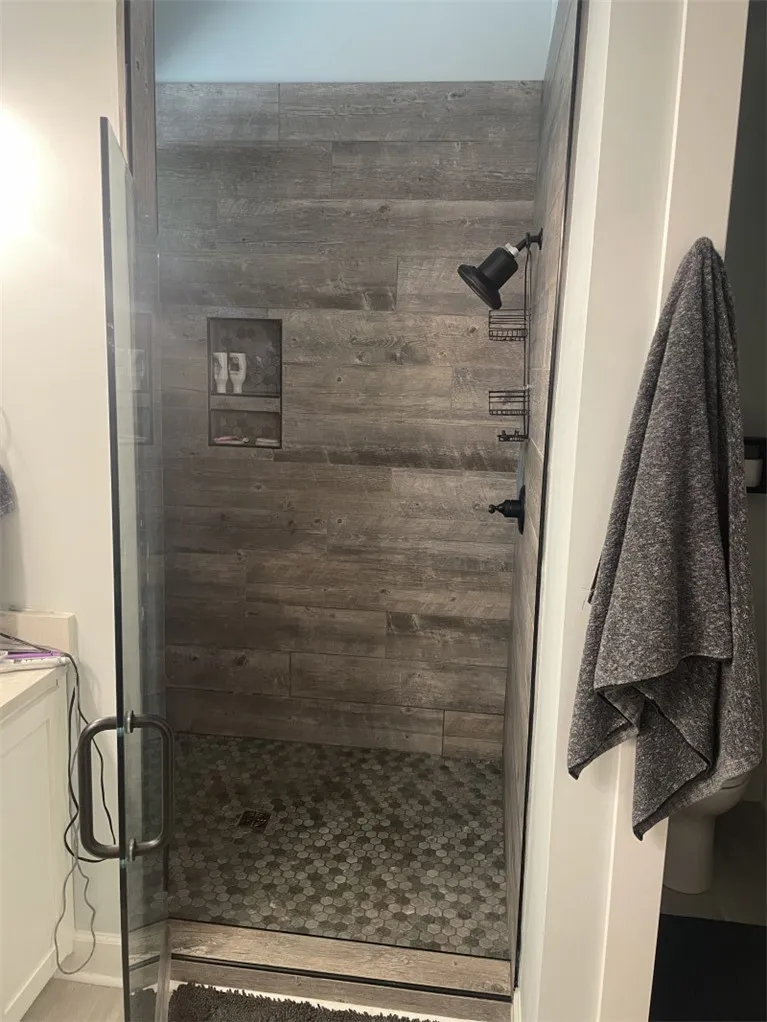 A modern shower with wood-look tile walls offers a refreshing bathing experience.