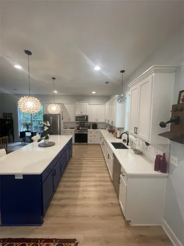 Culinary aspirations find their perfect setting in this well-appointed kitchen, featuring a spacious island and gleaming countertops.
