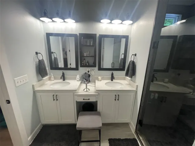 Twin vanities with elegant black fixtures and matching framed mirrors create a harmonious and functional bathing space.