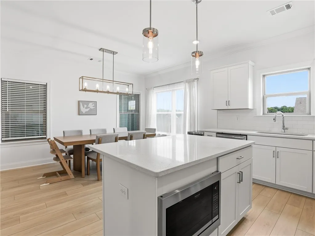A well-lit culinary space seamlessly flows into the adjacent dining area, creating an ideal setting for gatherings.
