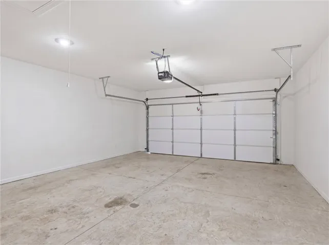 A spacious, well-lit garage offers ample parking and additional storage solutions.