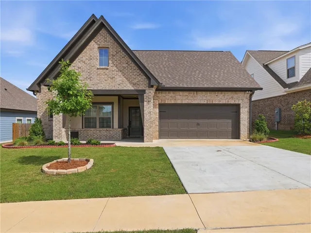 A classic brick exterior with a welcoming porch and well-maintained lawn.
